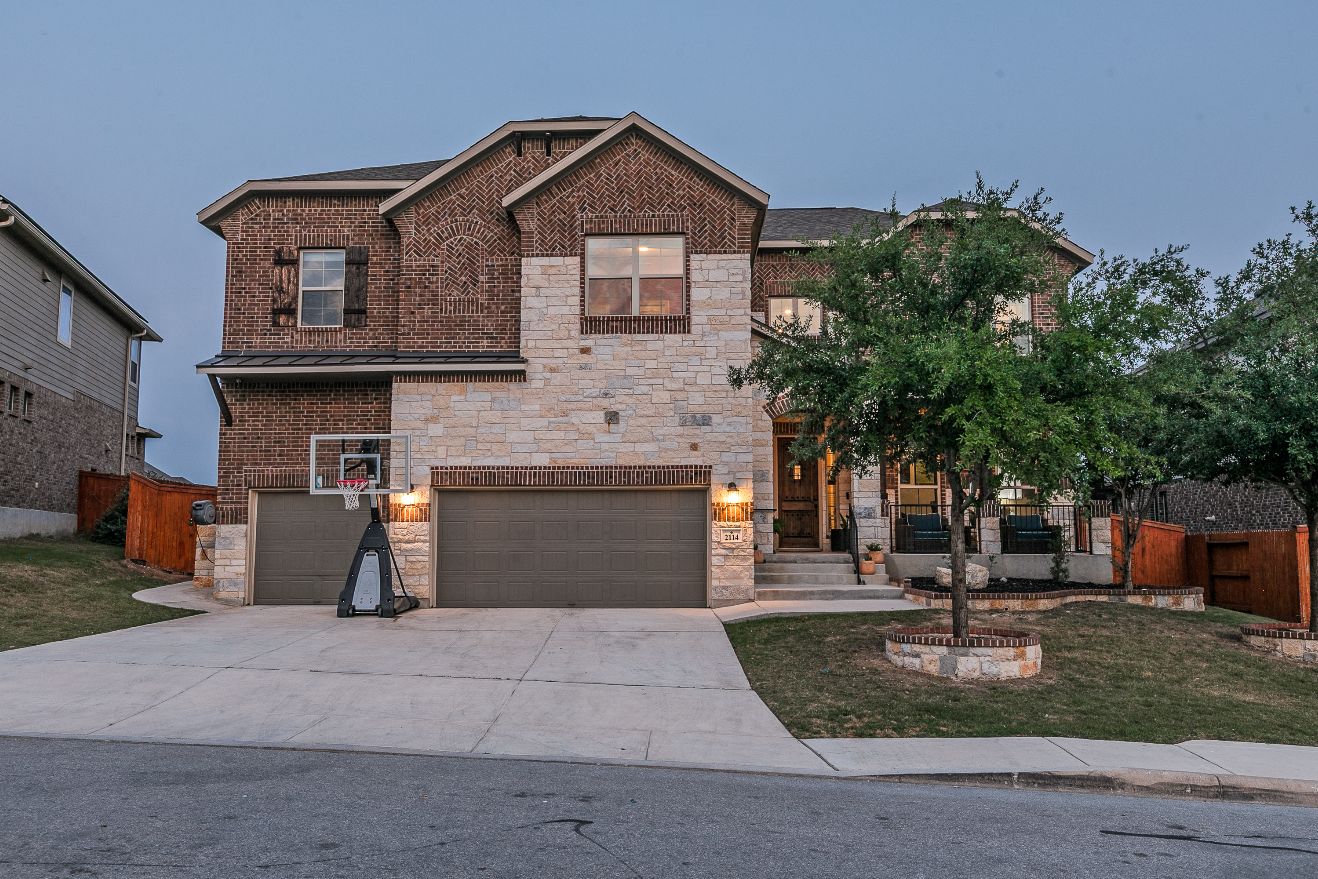 Two-story brick and stone home at dusk
